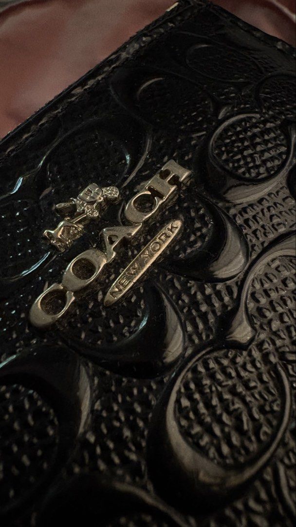 Original Coach Coin purse (Category: Wallets & Card holders) located in Manila. Submitted by coolflower-e6627b (Listing ID 1468339510, Image 3). Description: - Brand: Coach - Material: Black patent leather with signature debossed logo pattern - Hardware: Gold-tone - Features: Secure zipper closure, attached keyring chain, and clear ID window on the back - Condition: Signs of wear visible on edges and patent coating - Perfect for organizing cards 
