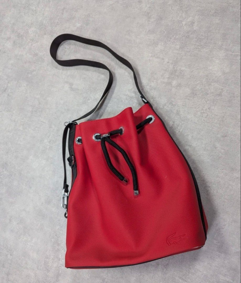 Original Lacoste bucket bag (Category: Cross-body Bags) located in Meycauayan. Submitted by ms.einz (Listing ID 1468340800, Image 2). Description: - Brand: Lacoste Original - Color: Brick red with black branded strap - Closure: Drawstring with metal Lacoste hardware - Interior: Black fabric lining with zip and slip pockets - Condition: Clean and well-maintained #lacoste #lacostebag #lacostebucketbag #lacostedrawstringbag.