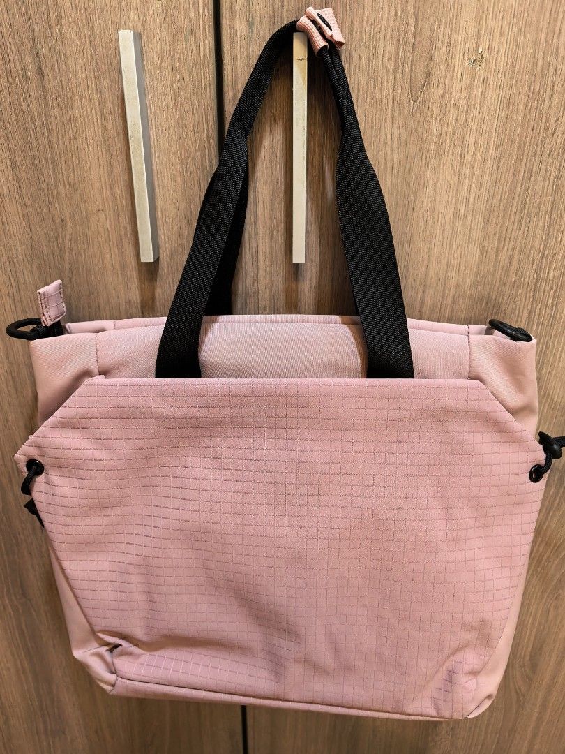 Outbound Activeclassy Tote Bag Pink (Category: Tote Bags) located in Manila. Submitted by maifabfinds (Listing ID 1468460070, Image 3). Description: - Brand: Activeclassy - Color: Pink with silky pink lining - Condition: Brand new with original tag attached - Exterior: Grid pattern texture on the front pocket, black handles, top zip closure, and side D-rings for a shoulder strap - Interior: Padded laptop section with a secure strap - Perfect for: