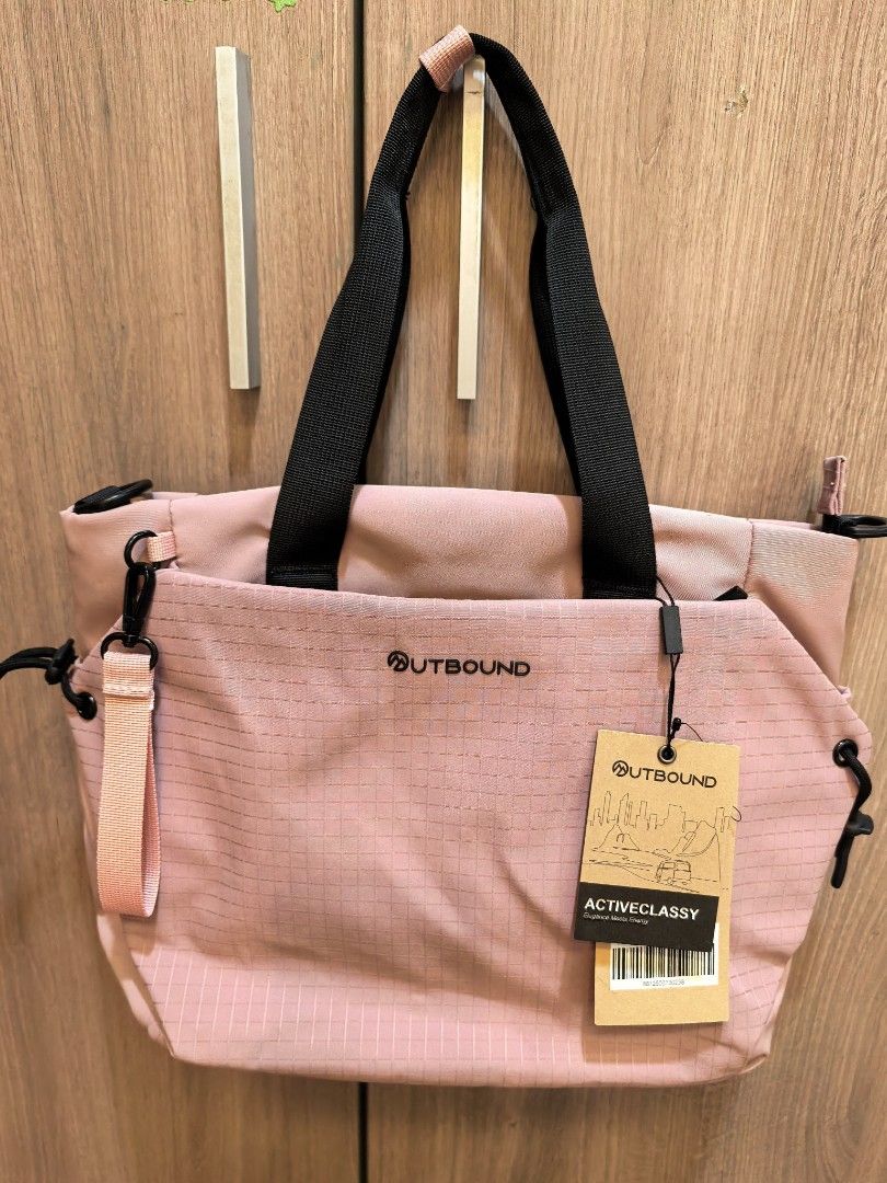 Outbound Activeclassy Tote Bag Pink (Category: Tote Bags) located in Manila. Submitted by maifabfinds (Listing ID 1468460070, Image 2). Description: - Brand: Activeclassy - Color: Pink with silky pink lining - Condition: Brand new with original tag attached - Exterior: Grid pattern texture on the front pocket, black handles, top zip closure, and side D-rings for a shoulder strap - Interior: Padded laptop section with a secure strap - Perfect for: