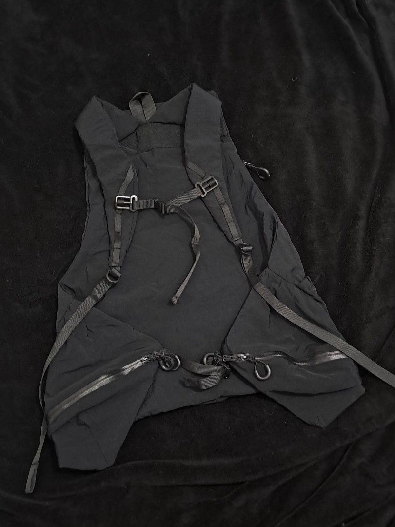 Outdoor Garment Step Out Vest (Category: Backpacks) located in Puerto Princesa. Submitted by jercksthriftph (Listing ID 1468391749, Image 3). Description: Outdoor Garment Step Out Vest - Sleek black technical backpack vest hybrid - Made from durable, water-resistant crinkled nylon - Multiple zipped compartments on front and sides for easy storage - Adjustable straps with heavy-duty buckles for a secure fit - Distinctive white mountain-style logo 