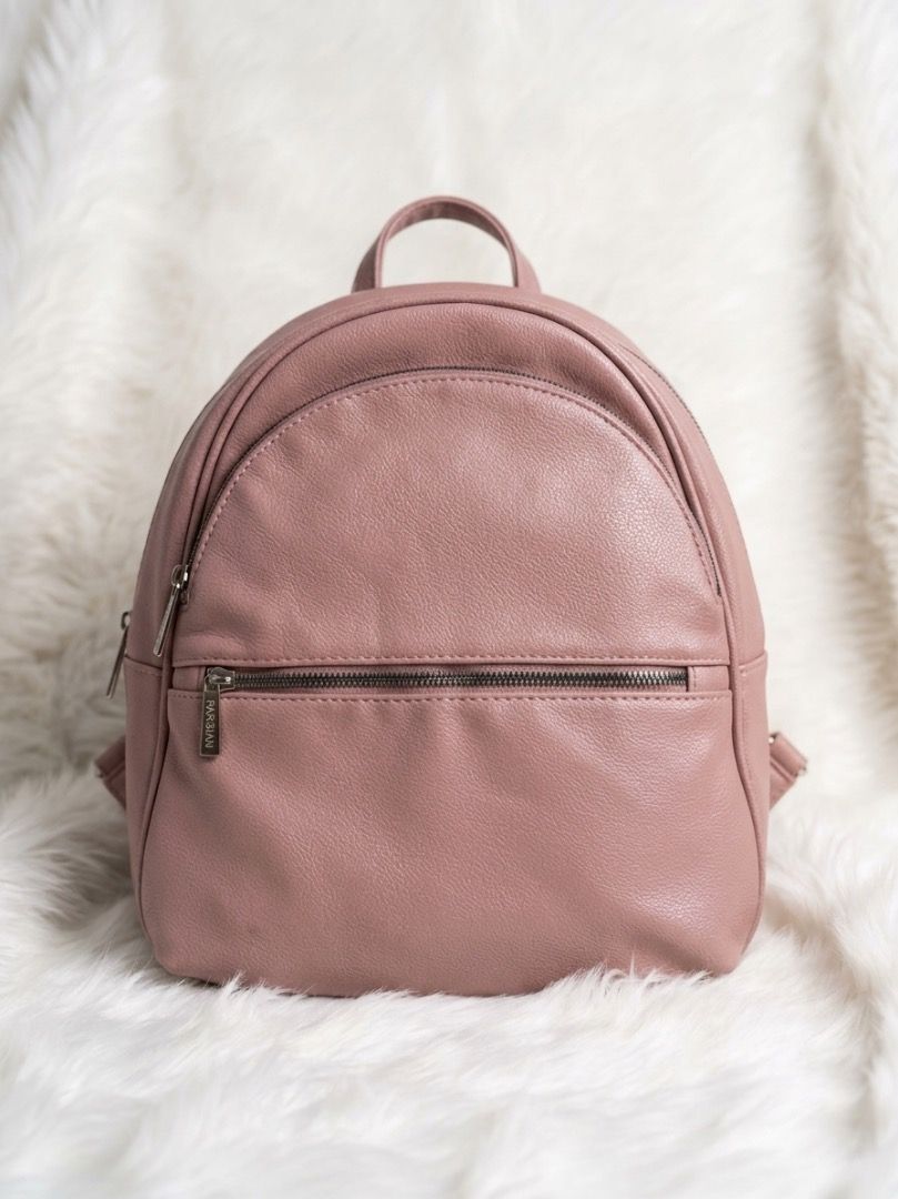 Parisian Pink Leatherette Casual Backpack (Category: Backpacks) located in Laoac. Submitted by pj_declutters (Listing ID 1468425833, Image 1). Description: - Brand: Parisian - Material: Dusty pink faux leather (clean, no scuffs) - Compartments: Main zip compartment, front zippered pocket, internal slip pocket - Straps: Dual shoulder straps and top grab handle - Size: Ideal daily bag for phone, wallet, keys, and essentials.