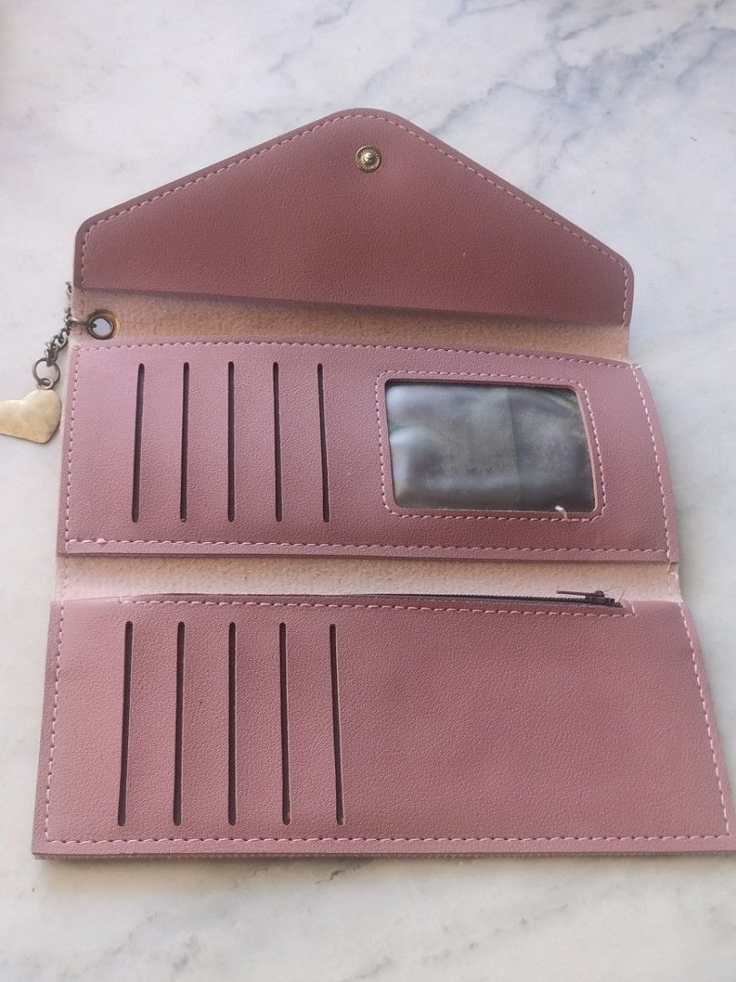 Pink Envelope Long Wallet with Heart Charm (Category: Wallets & Card holders) located in Las Pinas. Submitted by cozychic19 (Listing ID 1468434649, Image 2). Description: Dusty pink faux leather long wallet featuring an envelope flap with snap closure and a cute gold heart charm. Inside includes multiple card slots, an ID window, and a zippered pocket with clean lining. Stylish and functional!.