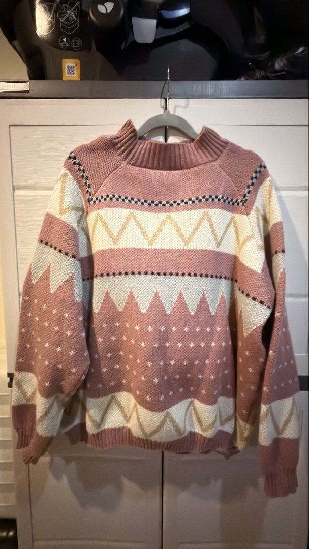 Pink patterned knit sweater with geometric design (Category: Coats, Jackets and Outerwear) located in Manila. Submitted by adoptmypreloveditems (Listing ID 1468477776, Image 1). Description: - Style: Cozy knit sweater with geometric pattern in dusty pink, cream, beige, and black - Fit: Relaxed fit with drop shoulders for ultimate comfort - Details: Chic mock neck collar, ribbed cuffs, and ribbed hem - Feel: Soft texture throughout, perfect for co