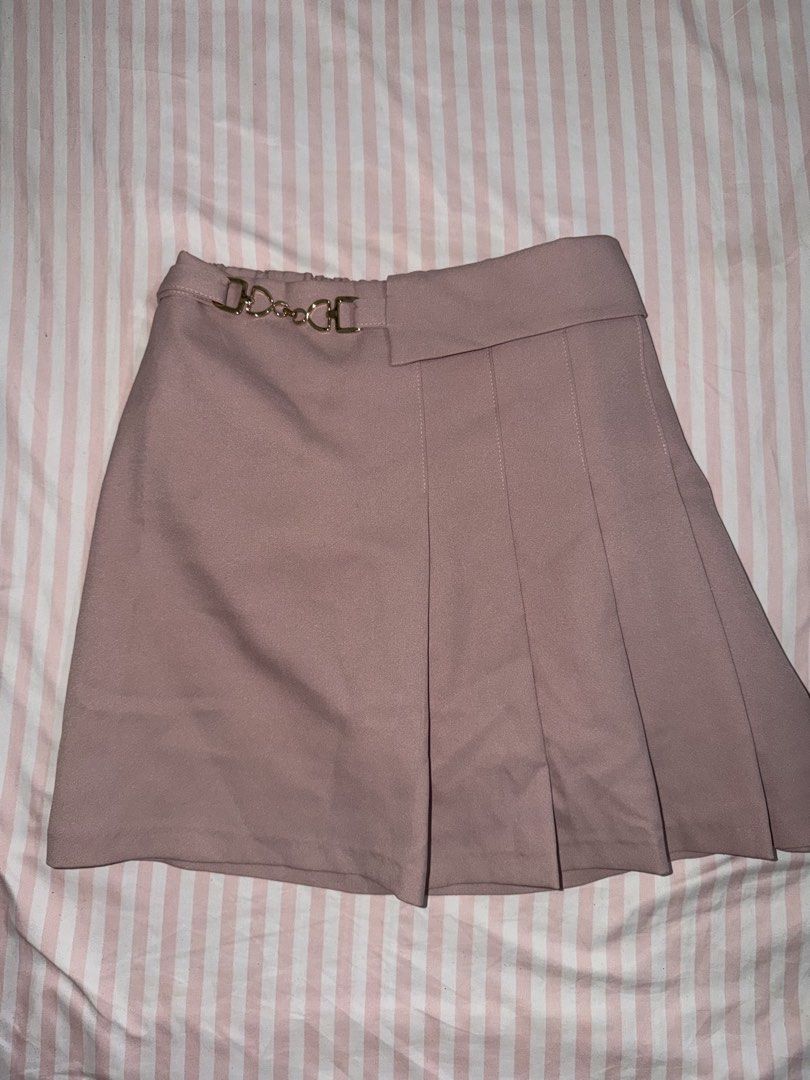 Pink Pleated Skort with Gold Chain Accent (Category: Skirts) located in Taguig. Submitted by deguzmanke83356 (Listing ID 1468361569, Image 1). Description: - Color: Dusty pink - Design: Side pleats on the right with a chic gold metallic chain accent - Comfort: Elasticated back waistband and smooth structured fabric - Coverage: Built-in inner shorts underneath - Perfect for casual days or dressed-up looks!.