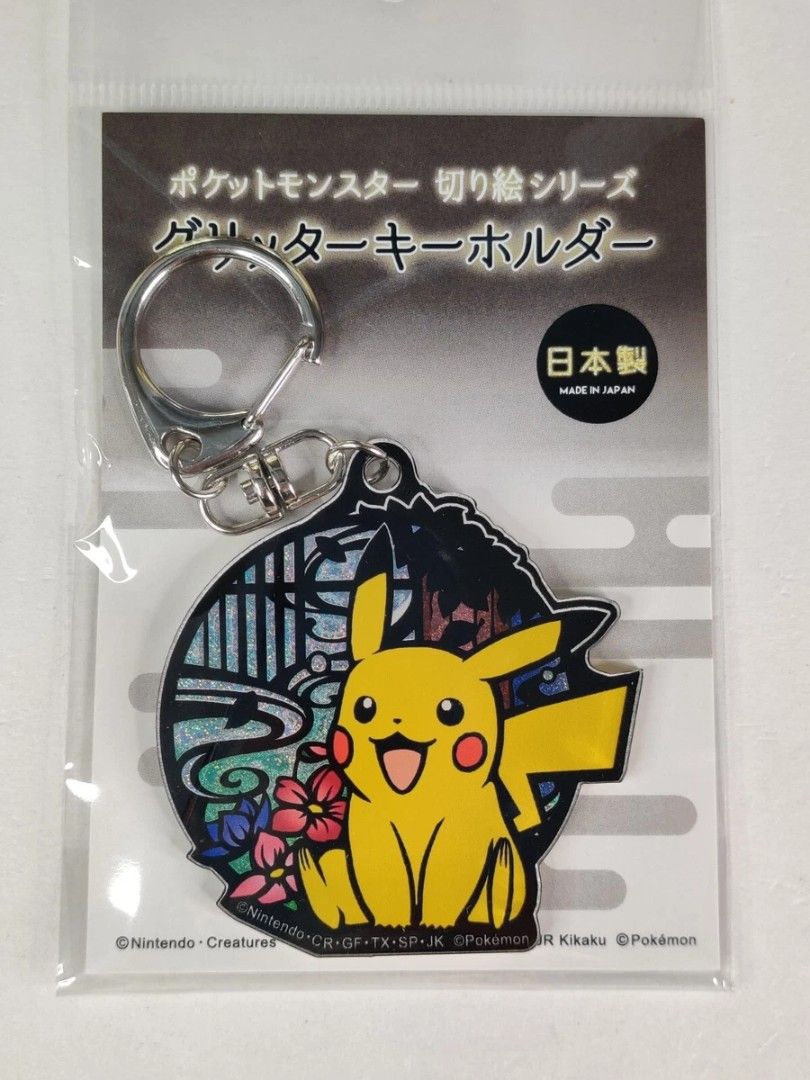 Pokemon Kiri-e Series Pikachu Glitter Keychain (Category: Character Goods) located in Quezon City. Submitted by curatedbymissgee (Listing ID 1468297806, Image 2). Description: - Authentic Pokemon Kiri-e paper-cut art style keychain - Features Pikachu with flowers and Japanese background - Shiny foil effect with glitter details - Official Nintendo licensed merchandise, made in Japan - Brand new and still sealed in original packaging with header ca