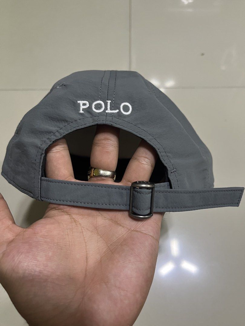 Polo Ralph Lauren Gray Cap (Category: Caps & Hats) located in Quezon City. Submitted by flip_da_cash (Listing ID 1468450513, Image 3). Description: - Brand: Polo Ralph Lauren - Material: Lightweight gray nylon with inner mesh lining - Design: White embroidered pony logo on front, 'POLO' embroidery above back strap - Closure: Adjustable metal buckle stamped with logo - Details: Includes blue brand tag inside - Condition: Excellent, ready to wear -