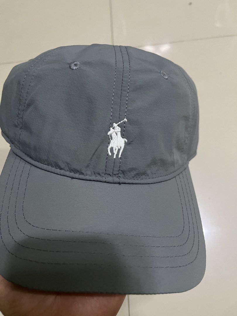 Polo Ralph Lauren Gray Cap (Category: Caps & Hats) located in Quezon City. Submitted by flip_da_cash (Listing ID 1468450513, Image 2). Description: - Brand: Polo Ralph Lauren - Material: Lightweight gray nylon with inner mesh lining - Design: White embroidered pony logo on front, 'POLO' embroidery above back strap - Closure: Adjustable metal buckle stamped with logo - Details: Includes blue brand tag inside - Condition: Excellent, ready to wear -