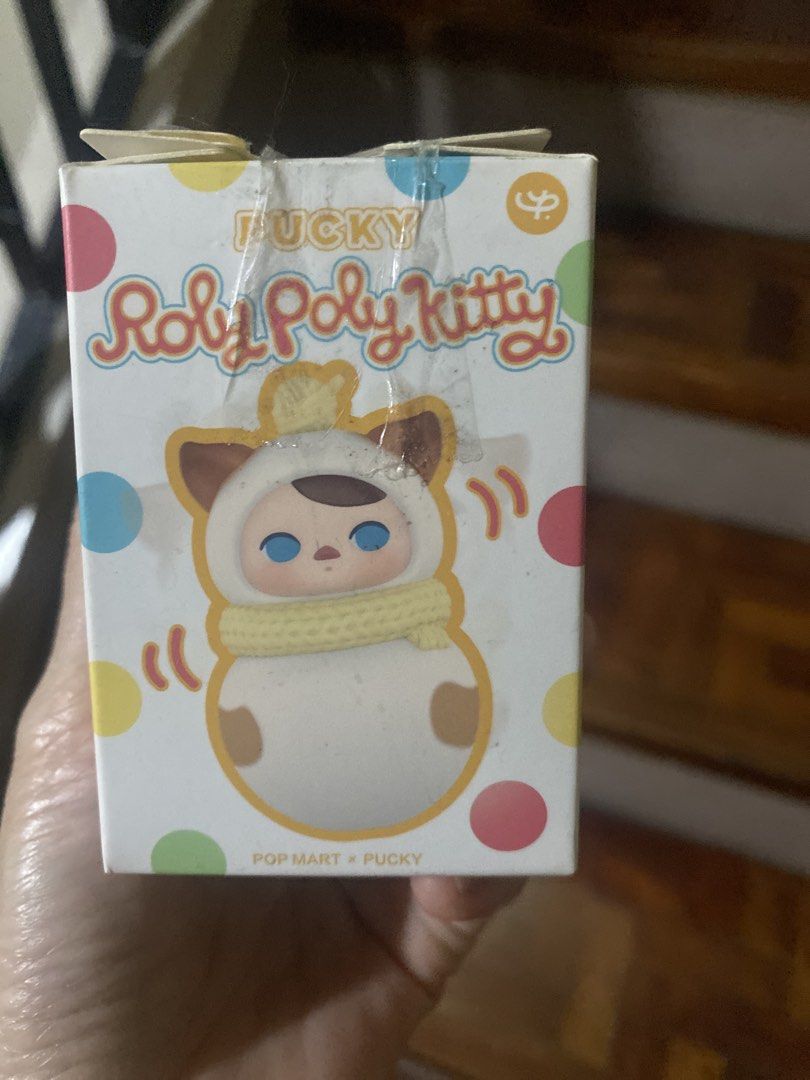 POP MART Pucky Roly Poly Kitty Collection ( Siamese) (Category: Designer & Blind Box Toys) located in Manila. Submitted by nicestuff.ph (Listing ID 1468302546, Image 2). Description: - Brand: POP MART x Pucky - Series: Roly Poly Kitty (Siamese) - Condition: Box has tape at the top flap - Packaging: Colorful polka dot design with front character illustration -Good used condition -Some scratches (pics provided) .