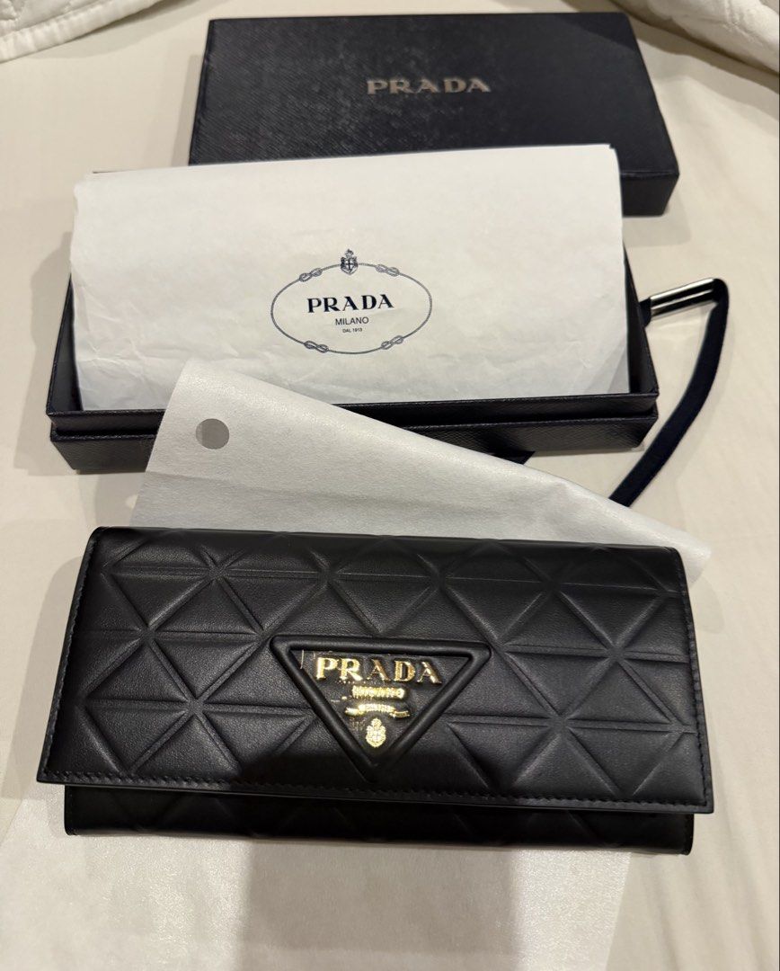 Prada Black Leather Long Wallet With Box (Category: Luxury Bags & Wallets) located in Pasig City. Submitted by fz718 (Listing ID 1468422018, Image 2). Description: - Authentic Prada wallet in classic black quilted leather - Luxurious gold-tone hardware and iconic front triangle logo plaque - Secure snap button closure - Interior features multiple card slots, slip compartments, and a zippered coin pocket - Crafted in Italy - Comes with original br