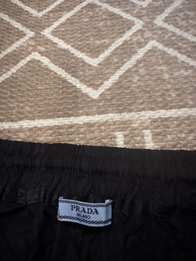 Prada Black Nylon Shorts Size M (Category: Shorts) located in Bulacan. Submitted by zyannechlo86360 (Listing ID 1468343116, Image 2). Description: - Color: Black - Material: Lightweight nylon - Size: Medium (M) - Waistband: Elastic with adjustable drawstring - Branding: Iconic Prada triangular metal logo plaque on left hem - Condition: Brand new with interior brand and care tags attached - Style: Simple slip-on.