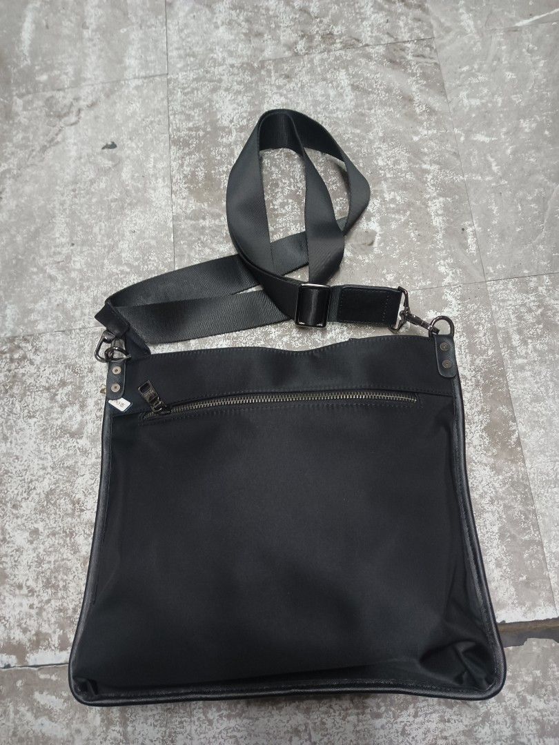 Prada Milano Black Nylon Crossbody Bag (Category: Sling Bags) located in Baguio. Submitted by brandeditems16 (Listing ID 1468478990, Image 2). Description: - Authentic Prada Milano black nylon crossbody bag - Sleek silver-tone hardware with iconic metal triangular logo plaque - Convenient front zip pocket and top zipper closure - Adjustable black canvas strap with secure metal clips - Branded fabric interior lining with metal logo plate - Compact