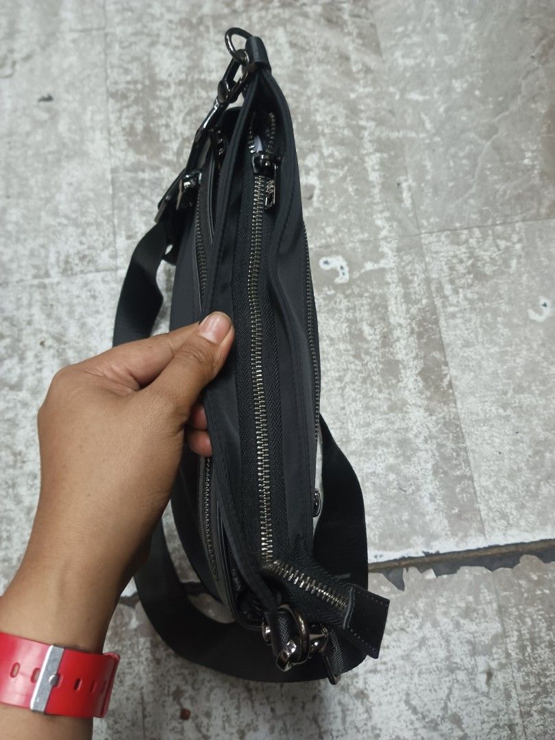 Prada Milano Black Nylon Crossbody Bag (Category: Sling Bags) located in Baguio. Submitted by brandeditems16 (Listing ID 1468478990, Image 3). Description: - Authentic Prada Milano black nylon crossbody bag - Sleek silver-tone hardware with iconic metal triangular logo plaque - Convenient front zip pocket and top zipper closure - Adjustable black canvas strap with secure metal clips - Branded fabric interior lining with metal logo plate - Compact