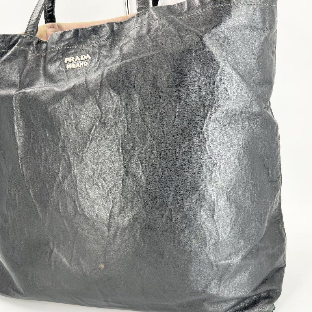 Prada Milano Reversible Tote Bag Leather Black (Category: Tote Bags) located in Mandaluyong City. Submitted by huntervip (Listing ID 1468304413, Image 2). Description: - Authentic Prada Milano reversible leather tote bag in black - Soft textured crinkled finish with dual comfortable shoulder straps - Features iconic front silver-tone Prada Milano logo lettering - Spacious everyday shoulder bag design for all your essentials - Includes certificate