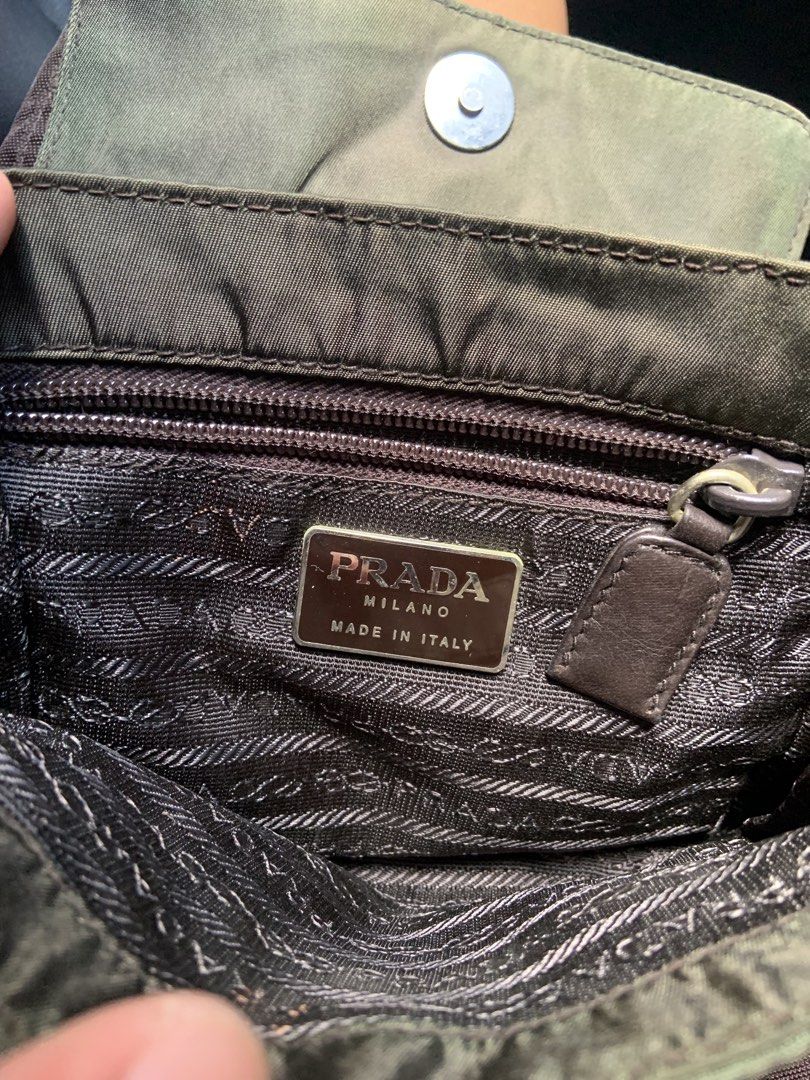 Prada Nylon Flap Handbag Olive Green -missing sling (Category: Luxury Bags & Wallets) located in Angeles City. Submitted by manlapidma26771 (Listing ID 1468312524, Image 2). Description: - Authentic vintage Prada nylon handbag in a chic olive green shade - Features the iconic triangular metal logo plaque on the front flap with secure snap button closure - Interior lined with signature Prada logo jacquard fabric - Includes an inner zip pocket with