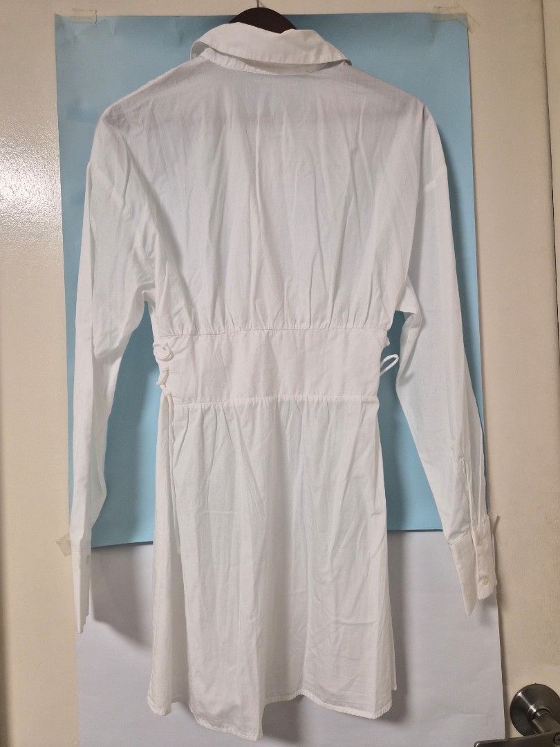 Pull&Bear White Button-Up Shirt Dress Size M (Category: Dresses) located in Manila. Submitted by prelovedbyc.hannah (Listing ID 1468358224, Image 2). Description: - Brand: Pull&Bear - Style: White button-down shirt dress - Size: M (EUR/USA M, MEX 28) - Features: Long sleeves with buttoned cuffs, classic collar, front button closure, and laced side waist details for an adjustable fit - Condition: Noticeable yellowing stains around the inner collar