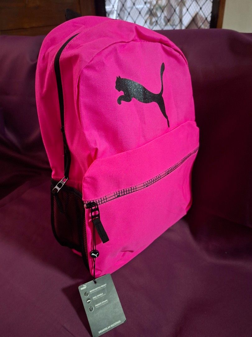 Puma Pink Grandslam Backpack With Tags (Category: Backpacks) located in Cavite. Submitted by vastowl_7d1ce5 (Listing ID 1468330285, Image 2). Description: - Brand new with original tags attached - Eye-catching bright pink design with a bold black Puma logo - Comfortable adjustable padded straps and sturdy top handle - Convenient side mesh pocket for water bottles - Secure zipper closure for the main compartment.