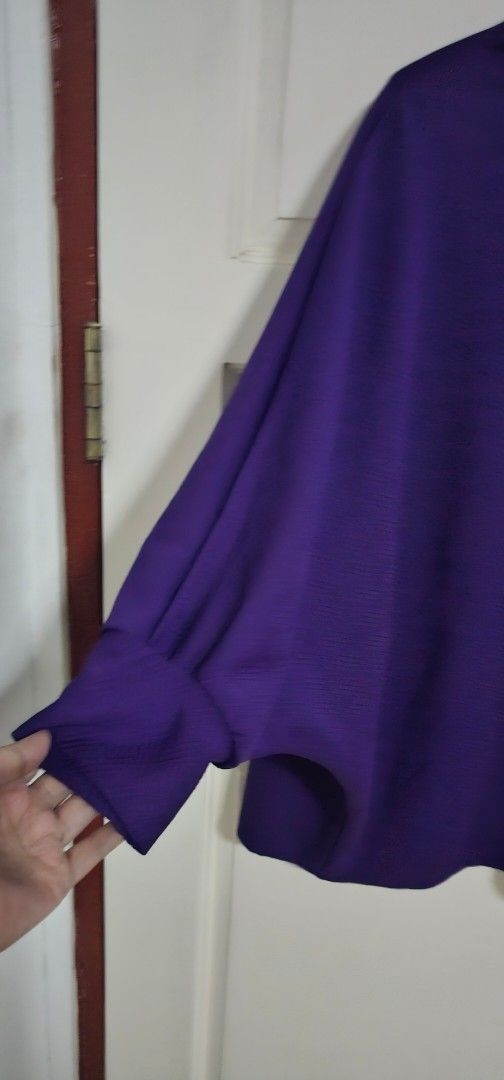 Purple long sleeve blouse (Category: Longsleeves) located in Davao. Submitted by sachigo (Listing ID 1468384196, Image 2). Description: - Color: Vibrant purple - Style: Loose fit with round neckline - Sleeves: Long sleeves with trendy cinched cuffs - Fabric: Lightweight and textured for all-day comfort - Versatility: Easy to style with both jeans and skirts - Condition: Brand new / Excellent.