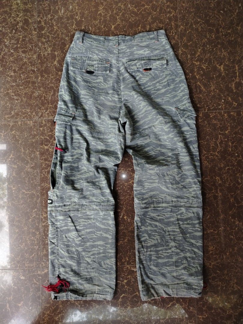 Quiksilver Tiger Camo Zip-off Cargo Pants (Category: Jeans) located in Alegria. Submitted by goofy_ripper (Listing ID 1468374575, Image 1). Description: - Brand: Quiksilver - Style: Grey tiger camouflage cargo pants with versatile zip-off design (converts into shorts) - Features: Multiple functional pockets, stylish red pull cords on zippers and leg cuffs, and signature woven Quiksilver logo patch on the cargo pocket - Closure: Classic button fly