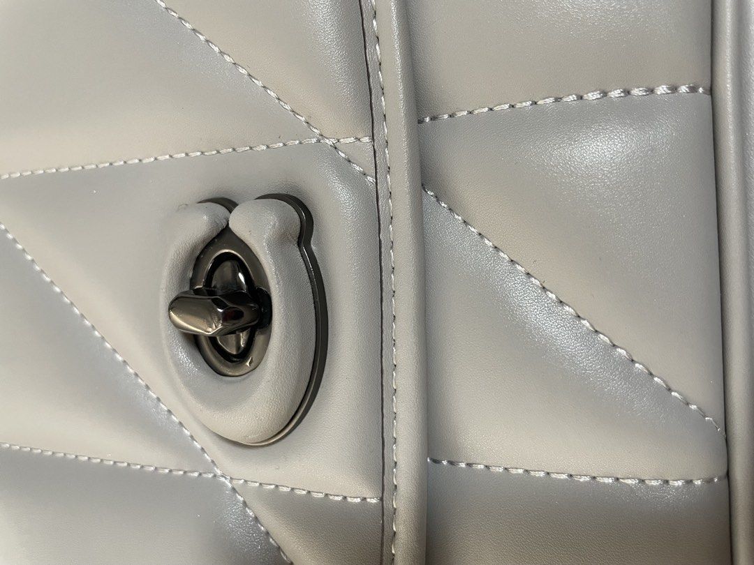 Quilted Grey Crossbody Bag with Chain Strap (Category: Luxury Bags & Wallets) located in Quezon City. Submitted by tor_ash (Listing ID 1468322233, Image 3). Description: - Color: Light grey - Material: Smooth faux leather with chevron stitch detailing - Hardware: Dark gunmetal chain strap and front turn-lock closure - Structure: Boxy and structured shape - Interior: Clean lining with dual chain pass-through grommets - Size: Compact, perfect for d
