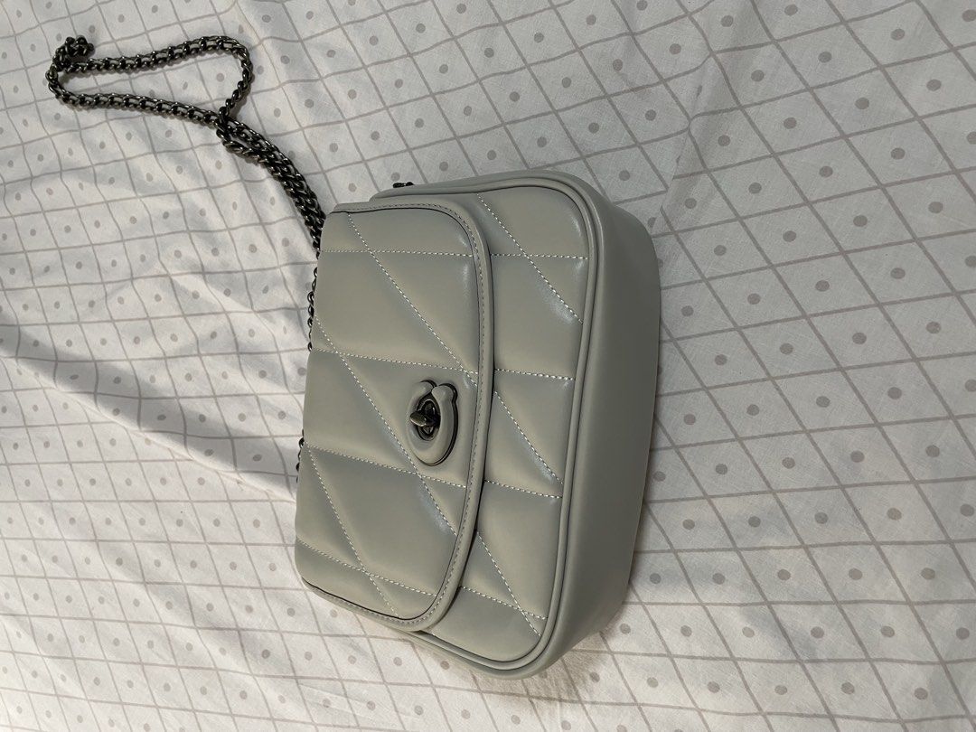 Quilted Grey Crossbody Bag with Chain Strap (Category: Luxury Bags & Wallets) located in Quezon City. Submitted by tor_ash (Listing ID 1468322233, Image 1). Description: - Color: Light grey - Material: Smooth faux leather with chevron stitch detailing - Hardware: Dark gunmetal chain strap and front turn-lock closure - Structure: Boxy and structured shape - Interior: Clean lining with dual chain pass-through grommets - Size: Compact, perfect for d