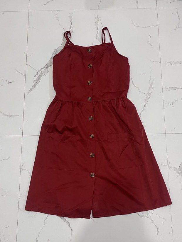 Red button-front spaghetti strap sundress with pockets (Category: Dresses) located in Mabalacat. Submitted by xyzamym (Listing ID 1468407381, Image 1). Description: - Color: Red - Style: Spaghetti strap sundress with tortoise shell front buttons - Features: Gathered waist and two functional front pockets - Fabric: Lightweight and breathable, perfect for warm weather - Versatility: Easy to style with sandals or sneakers - Condition: Clean and well