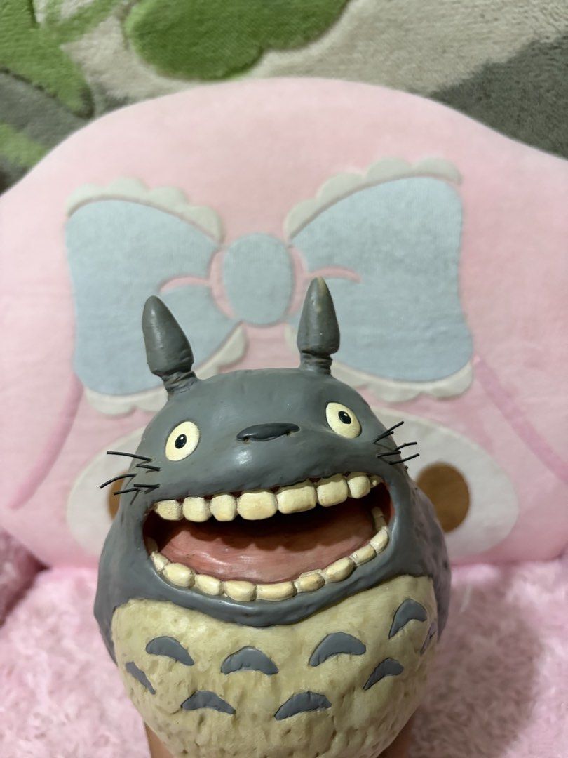 Roaring totoro coin bank (Category: Figurines & Statues) located in Naic. Submitted by rmcollectibles (Listing ID 1468437475, Image 2). Description: - Authentic Grey Totoro figurine featuring a playful wide-open mouth and detailed teeth - Textured furry belly and distinct whiskers for an accurate Studio Ghibli look - Classic two pointy ears on top (minor paint chip on the tip of one ear) - Stands upright firmly on a sleek dark base - Highly detai