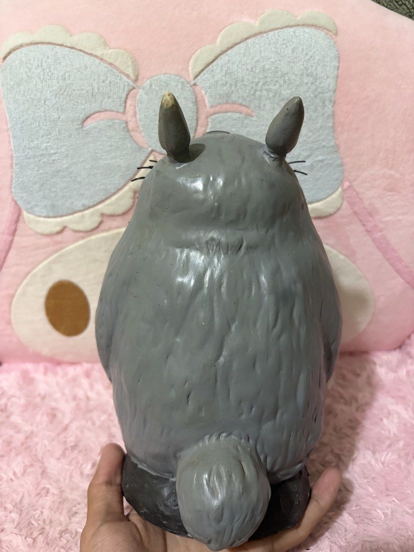 Roaring totoro coin bank (Category: Figurines & Statues) located in Naic. Submitted by rmcollectibles (Listing ID 1468437475, Image 3). Description: - Authentic Grey Totoro figurine featuring a playful wide-open mouth and detailed teeth - Textured furry belly and distinct whiskers for an accurate Studio Ghibli look - Classic two pointy ears on top (minor paint chip on the tip of one ear) - Stands upright firmly on a sleek dark base - Highly detai