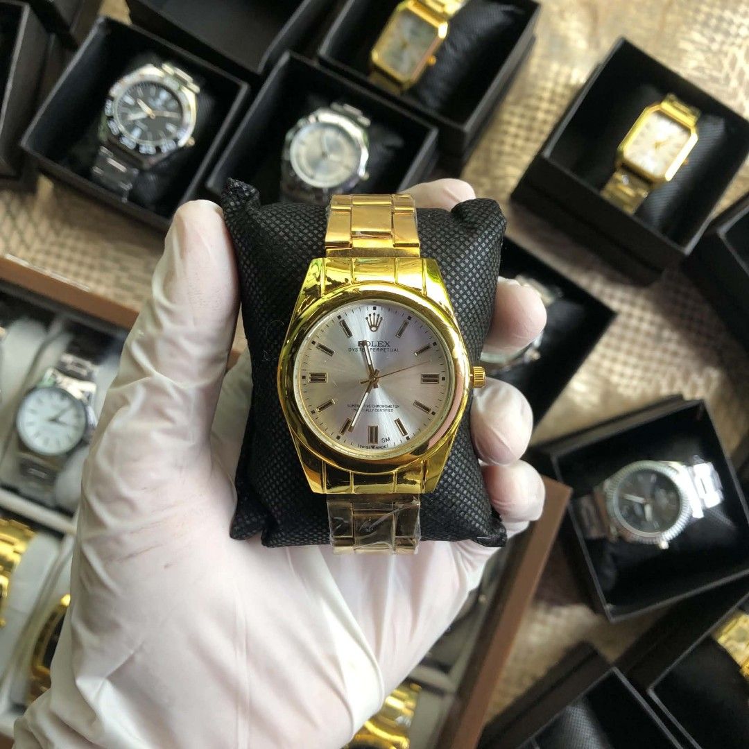 Rolex Oyster Perpetual Gold Watch (Category: Luxury Watches) located in Lucena. Submitted by jolo0419 (Listing ID 1468285092, Image 1). Description: - Model: Rolex Oyster Perpetual - Finish: Polished gold-tone case and matching metal bracelet - Dial: Silver dial with clean stick hour markers and signature crown at 12 o'clock - Condition: Brand new with protective plastic wrap still intact on the lower links - Style: Classic luxury dress watch - A
