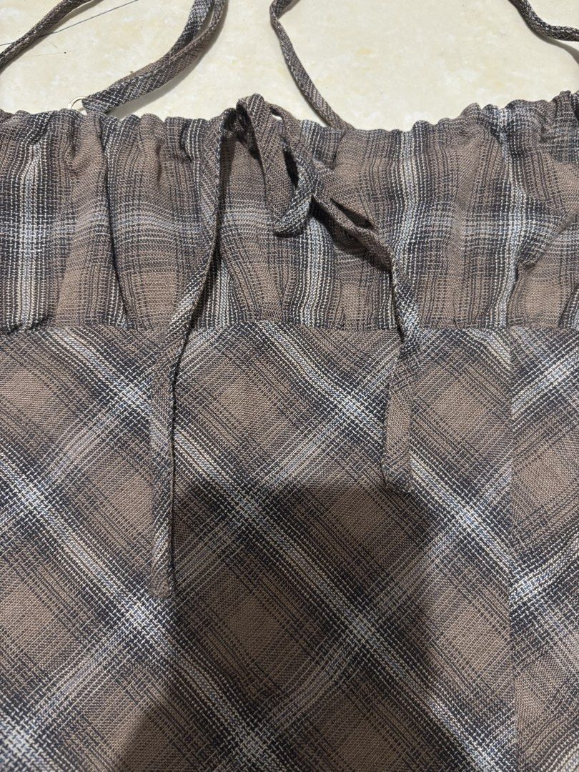 Romi Studios Brown Plaid Halter Mini Dress (Category: Dresses) located in Manila. Submitted by van390867 (Listing ID 1468411551, Image 2). Description: - Brand: Romi Studios Size: XS - Style: Brown plaid mini dress with a flared skirt shape - Details: Ruched bustline with adjustable tie string and thin straps - Fit: Zipper-free, slip-on design, fully lined inside - Occasion: Ideal for casual outings, malling, or date nights.