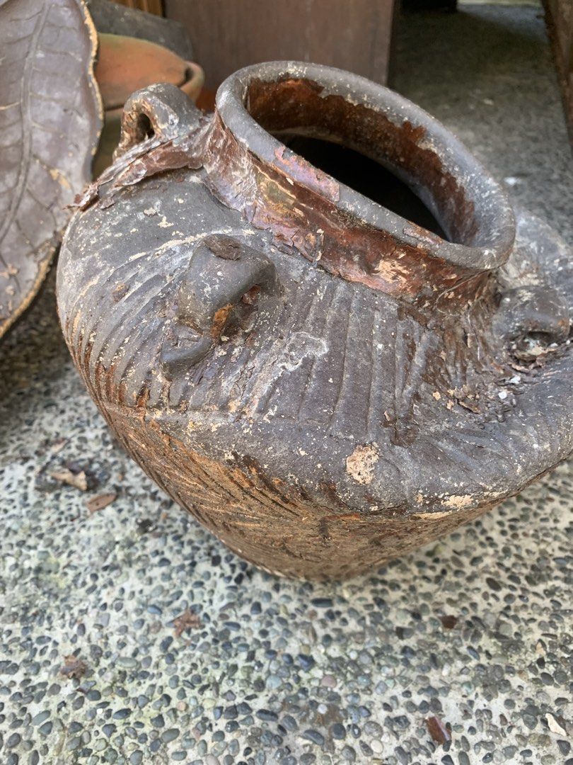Rustic textured ceramic jar with handles (Category: Vases & Decorative Bowls) located in Quezon City. Submitted by sojisup (Listing ID 1468314126, Image 3). Description: - Material: Solid earthenware with dark brown glaze - Design: Earth-toned with decorative vertical carvings and built-in side handles - Features: Open top rim with slightly flared lip and heavy base - Condition: Rustic texture showing natural aging, patina, and minor chips - Idea