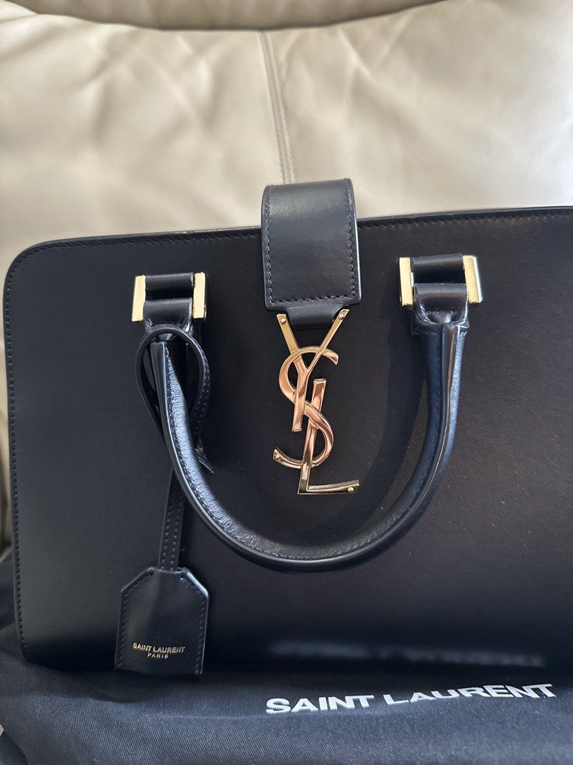 Saint Laurent YSL Cabas bag (Category: Luxury Bags & Wallets) located in Carmona. Submitted by jekslegaspi (Listing ID 1468290279, Image 3). Description: STORE BOUGHT - Brand: Saint Laurent (YSL) - Material: Premium black smooth calfskin leather - Hardware: Iconic gold-tone YSL interlocking logo with mirror shine - Structure: Structured rectangular shape with gold protective feet on the base - Straps: Dual top handles and a convenient detachable 