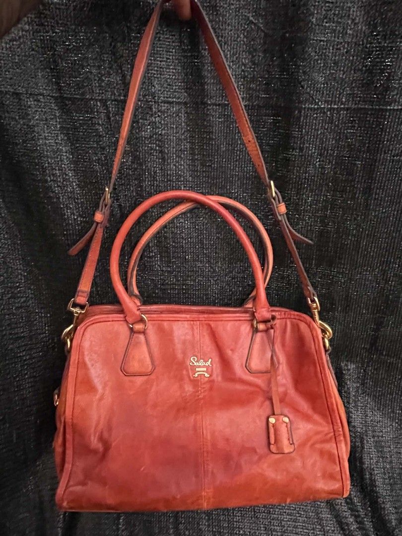 Salad Leather Shoulder Bag Handbag Orange (Category: Shoulder Bags) located in Manila. Submitted by buyingprelovedukayukay (Listing ID 1468321834, Image 1). Description: - Brand: Salad - Color: Vibrant Orange - Material: Genuine Leather - Hardware: Gold-tone - Straps: Dual top handles + long adjustable shoulder strap - Closure: Secure zip closure - Interior: Patterned fabric lining with branded cloth label and hanging debossed leather tag - Capac