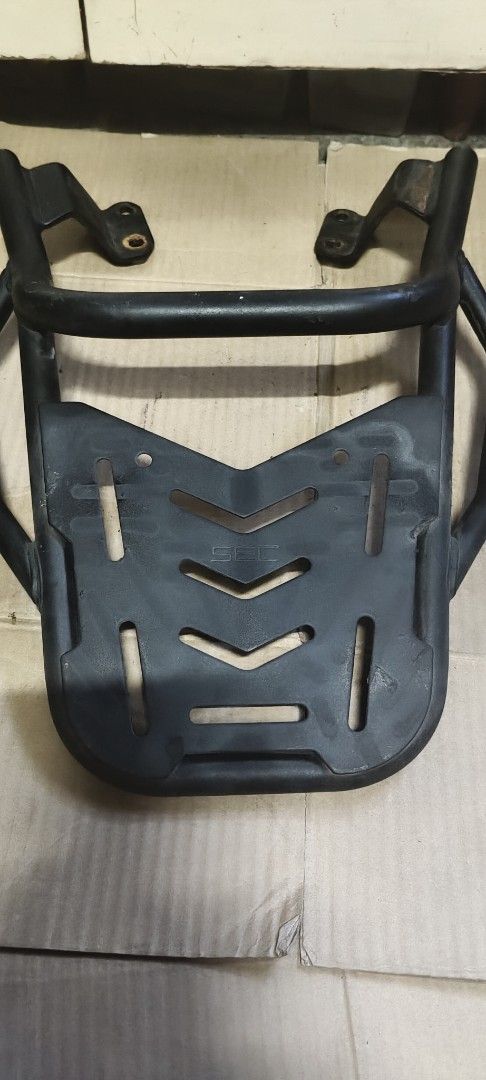 SEC Motorcycle Rear Top Box Rack Carrier (Category: Body Parts and Accessories) located in Manila. Submitted by roserallos42594 (Listing ID 1468341606, Image 2). Description: - Brand: SEC - Material: Heavy-duty tubular steel with sturdy mounting plate - Compatibility: Fits motorcycles with pre-drilled base brackets for straightforward installation - Features: Multiple cutouts and slots ideal for securing top boxes and cargo - Condition: Used with