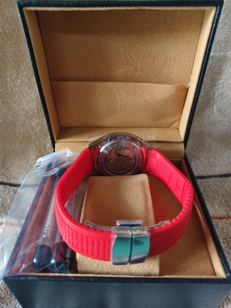 Seiko Automatic Watch with Red Strap and Presentation Box MOD (Category: Men's Watches) located in Manila. Submitted by rarewind.cb1244 (Listing ID 1468315484, Image 2). Description: - Brand: Seiko Automatic Watch - Dial: Black dial with clear white Arabic numerals and date window at 3 o'clock - Strap: Eye-catching bright red rubber strap equipped with a secure deployment clasp - Case Back: Transparent exhibition glass revealing the automatic mec