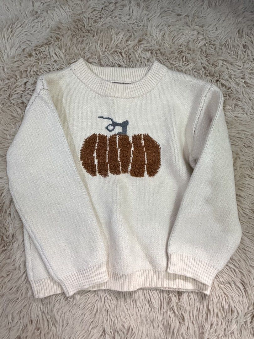 SHEIN Cream Pumpkin Knit Sweater (Category: Babies & Kids Fashion) located in Quezon City. Submitted by adagavin (Listing ID 1468328051, Image 1). Description: - Color: Cream with brown textured pumpkin graphic - Style: Relaxed fit, long sleeves, ribbed neckline, cuffs, and hem - Material: Comfortable knit - Flaw: Noticeable yellowish stain on the upper left shoulder area near the collar (please manage expectations) - Perfect for cozy autumn days