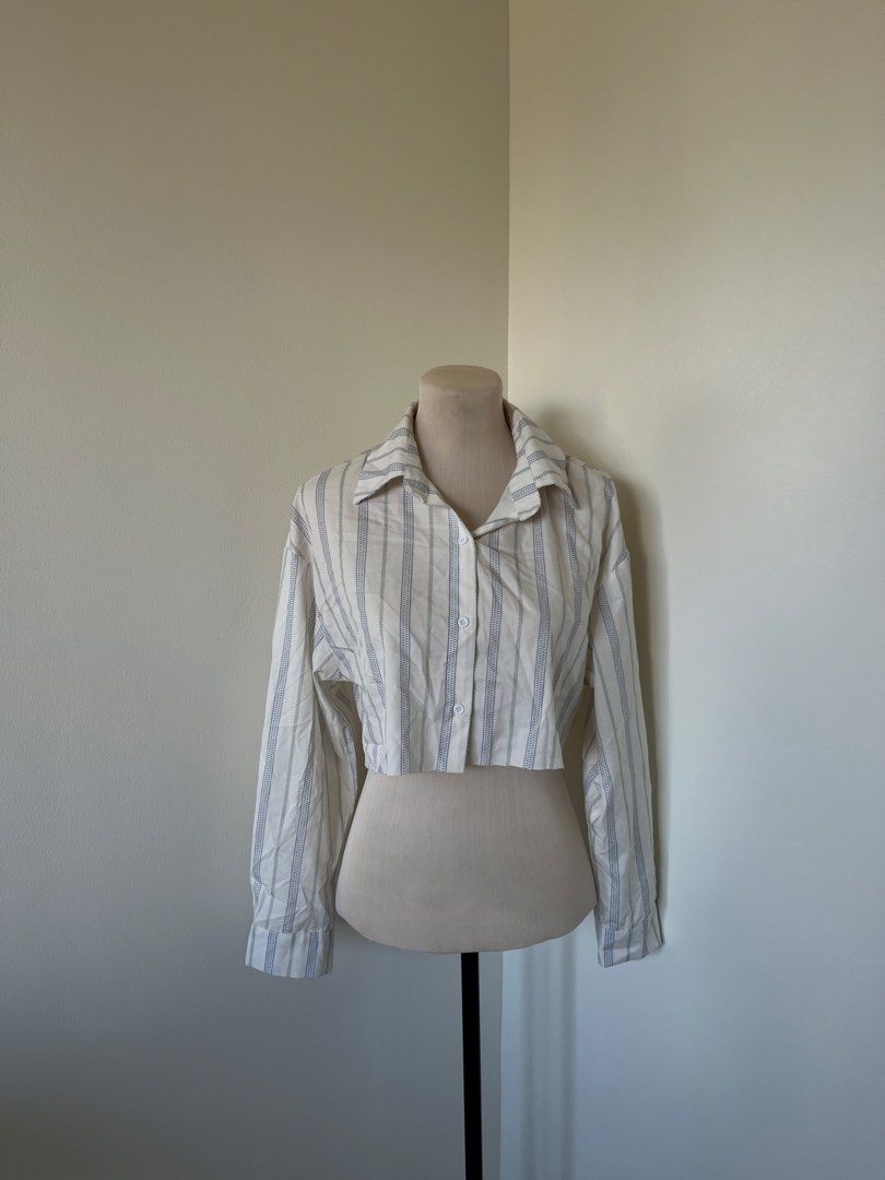 SHEIN Striped Long Sleeve Button-Up Crop Top (Category: Longsleeves) located in Mandaluyong City. Submitted by bravedeer.020ad7 (Listing ID 1468366025, Image 1). Description: - Style: White crop top with blue vertical stripes - Fit: Relaxed fit with a cropped length above the waist - Details: Long sleeves, spread collar, front button closure - Material: Lightweight and comfortable fabric.