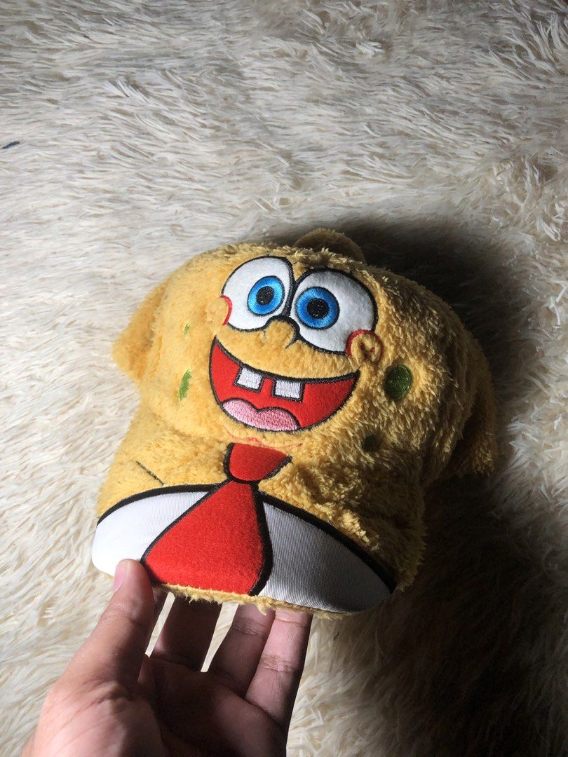 SpongeBob SquarePants Fuzzy Cartoon Cap Hat (Category: Caps & Hats) located in Maria Aurora. Submitted by kylerikathriftshop101010 (Listing ID 1468464192, Image 1). Description: Furry yellow baseball cap shaped like SpongeBob. Embroidered facial features with big blue eyes and happy expression. Attached white collar and red tie graphic right on the front. Fuzzy texture all over. Inner lining is yellow cotton with standard interior seams. Label sa