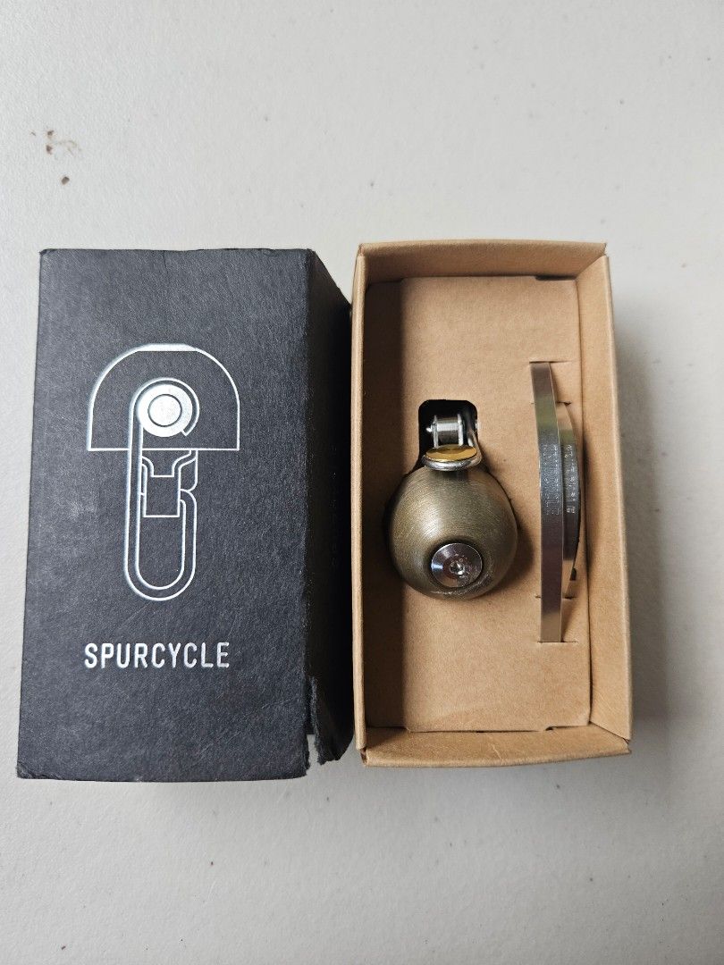 Spurcycle Bell (Category: Bicycles) located in Quezon City. Submitted by fliptongz (Listing ID 1468315370, Image 1). Description: Authentic Spurcycle Original Bicycle Bell (Silver / Raw / Gold Accents) for sale. Complete with original mounting metal bands (fits 22.2mm and 31.8mm handlebars). - Used condition. Shows visible signs of use, including scratches and scuffs around the top bolt/dome area as seen in the photos. - 100% fully functional. Th