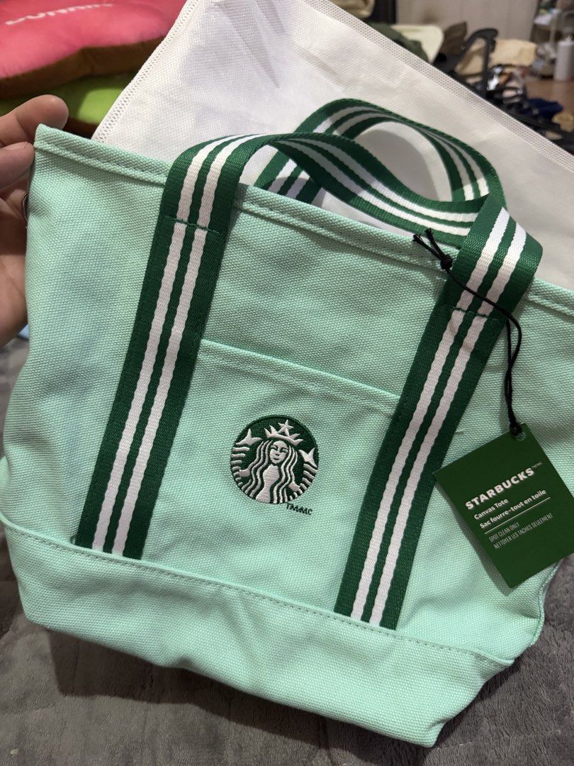 Starbucks Green Canvas Tote Bag with Strap (Category: Tote Bags) located in Angeles City. Submitted by lovedbyava (Listing ID 1468376569, Image 1). Description: - Brand: Starbucks - Color: Mint green with green and white striped handles - Condition: Brand new with tag attached - Features: Embroidered Starbucks siren logo on front slip pocket, detachable green shoulder strap - Material: Canvas (spot clean only) - Size: Handy everyday size, ideal f