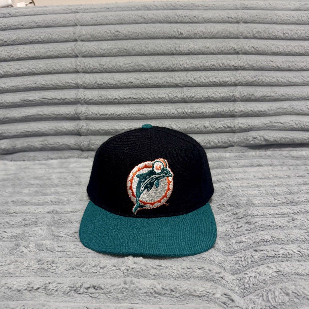 Starter Miami Dolphins Vintage Snapback Cap (Category: Caps & Hats) located in Agdangan. Submitted by kiiiiingg (Listing ID 1468436246, Image 1). Description: - Authentic vintage Starter snapback hat - Miami Dolphins embroidered logo on the front - Classic black crown, teal brim, and green undervisor - Officially licensed NFL product made of 100% wool - Adjustable plastic snap closure with iconic Starter star embroidery.