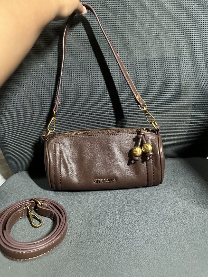 Steve Madden Brown Shoulder Bag (Category: Sling Bags) located in Davao. Submitted by ljgadd (Listing ID 1468432390, Image 1). Description: - Brand: Steve Madden - Color: Brown - Style: Compact barrel shoulder bag - Closure: Zip top with brass-tone hardware - Accents: Decorative dangling gold-tone sphere charms on knots - Strap: Includes a detachable long strap for versatility - Condition: Excellent / Ready to ship.