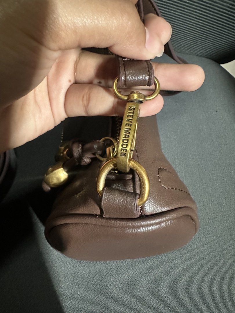 Steve Madden Brown Shoulder Bag (Category: Sling Bags) located in Davao. Submitted by ljgadd (Listing ID 1468432390, Image 2). Description: - Brand: Steve Madden - Color: Brown - Style: Compact barrel shoulder bag - Closure: Zip top with brass-tone hardware - Accents: Decorative dangling gold-tone sphere charms on knots - Strap: Includes a detachable long strap for versatility - Condition: Excellent / Ready to ship.