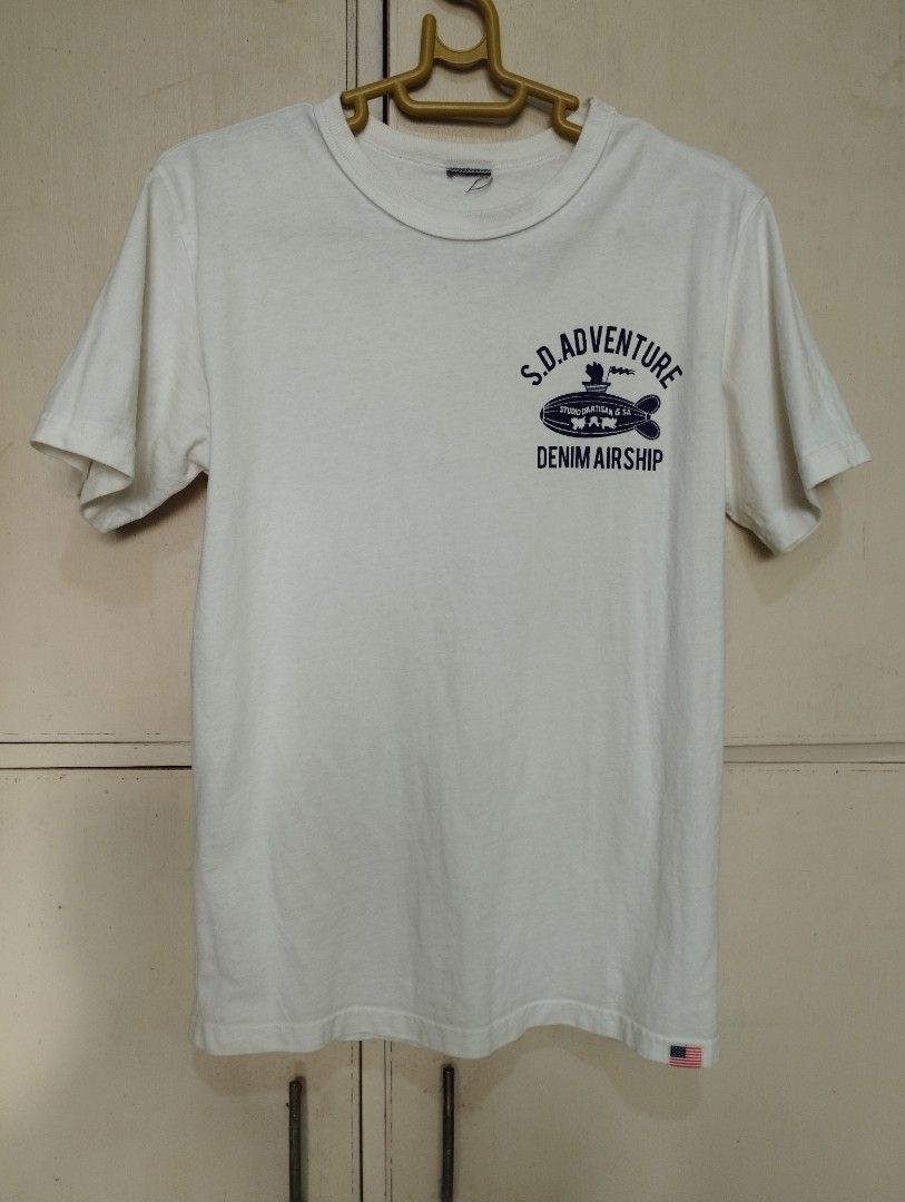 Studio D'Artisan (Category: Tshirts & Polo Shirts ) located in San Fernando. Submitted by nerosales (Listing ID 1468349867, Image 1). Description: - Brand: Studio D'Artisan - Origin: Assembled in JAPAN, fabric made in USA, - Color: White - Graphic: 'S.D. Adventure Denim Airship' design with a pig piloting an airship (front and back) - Ideal for: Studio D'Artisan enthusiasts Small: 17 x 25.5 inches Upper tag is cut. Intact yung dalawang tag sa bab