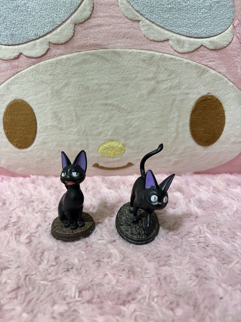 Studio Ghibli Jiji Cat Figures (Category: Figurines & Statues) located in Naic. Submitted by rmcollectibles (Listing ID 1468438181, Image 1). Description: - Authentic Studio Ghibli Jiji figurines (set of 2) - Includes one sitting Jiji and one walking Jiji with tail up - Features cute purple inner ears and detailed textured bases - Official stamp located on the bottom of each stand - Perfect size for a desk display or collection.
