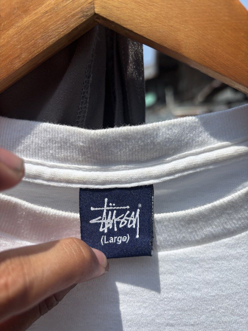 Stussy White Graphic Tee Size Large (Category: Tshirts & Polo Shirts ) located in General Santos City (Dadiangas). Submitted by rachelleclosets2026._gem (Listing ID 1468320117, Image 3). Description: - Brand: Stussy - Color: White - Size: Large - Material: 100% cotton (Assembled in Mexico) - Design: Bold graphic print on front lower right and back - Details: Ribbed crew neckline, short sleeves - Condition: Clean, great for everyday casual wear.