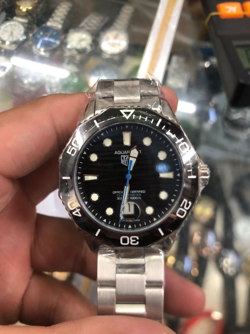 TAG Heuer Aquaracer Watch (Category: Luxury Watches) located in Manila. Submitted by odingepi-23571 (Listing ID 1468478673, Image 2). Description: - Brand: TAG Heuer Aquaracer - Movement: Chronometer certified automatic - Condition: Brand new, still wrapped in protective plastic film - Dial: Black wave pattern with silver hands, blue sweep seconds hand, and date window with magnifier at 3 o'clock - Bezel: Rotating black bezel - Material: Stainles