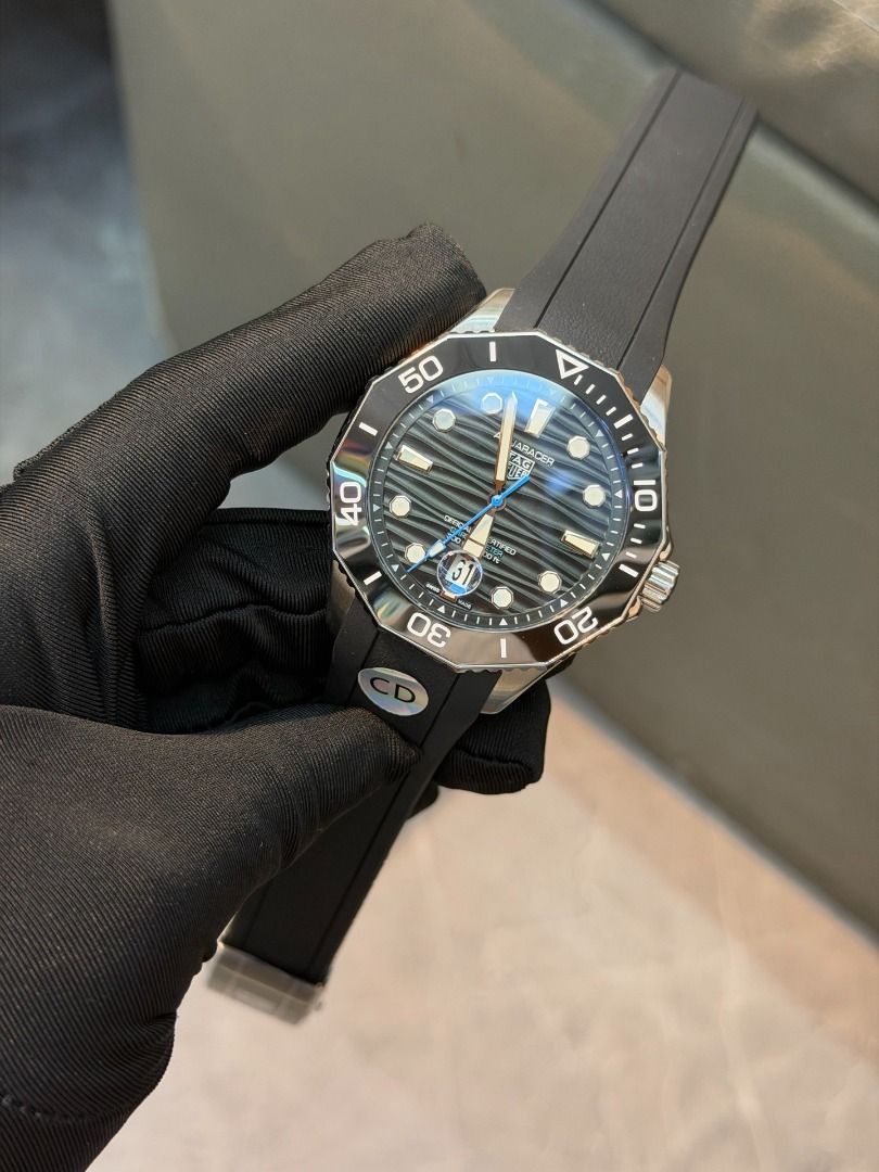 Tag heuer Automatic mechanical watch（1.1) (Category: Luxury Watches) located in Marikina City. Submitted by coolpenguin.4da29f (Listing ID 1468419009, Image 3). Description: - Brand: TAG Heuer Aquaracer luxury dive watch - Dial: Black wavy patterned dial with luminous hands, markers, blue seconds hand, and date window with magnifier at 6 o'clock - Bezel: Rotating ceramic bezel - Case: Stainless steel with polished sides and signed crown - Crystal