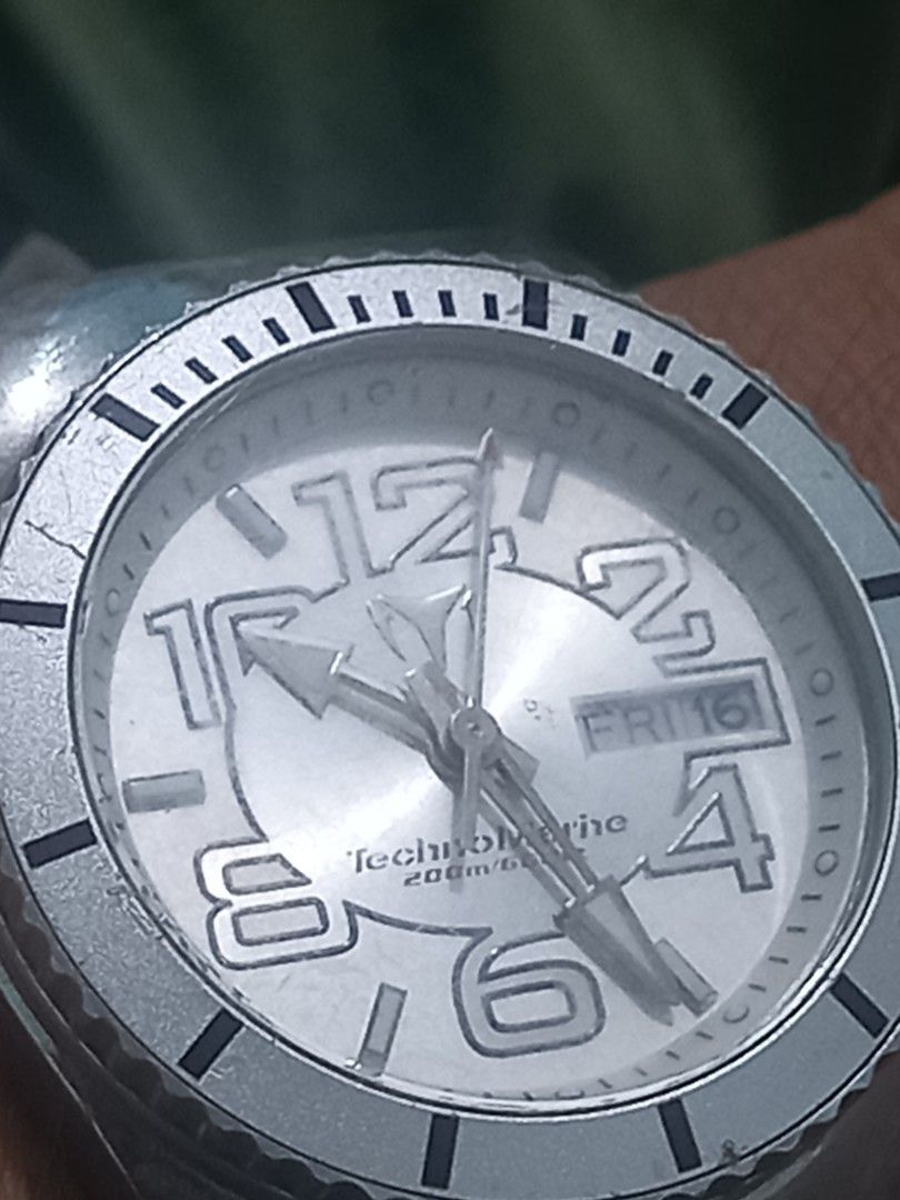 TechnoMarine watch white dial black leather strap (Category: Luxury Watches) located in Subic. Submitted by regiegabriel29 (Listing ID 1468431617, Image 3). Description: - Brand: TechnoMarine - Dial: White with large bold numbers (12, 2, 4, 6, 8, 10) - Features: Day and date display window near 3 o'clock - Case & Bezel: Silver-tone with minor hairline scratches from being worn a few times - Strap: Black leather with crocodile texture and metal bu