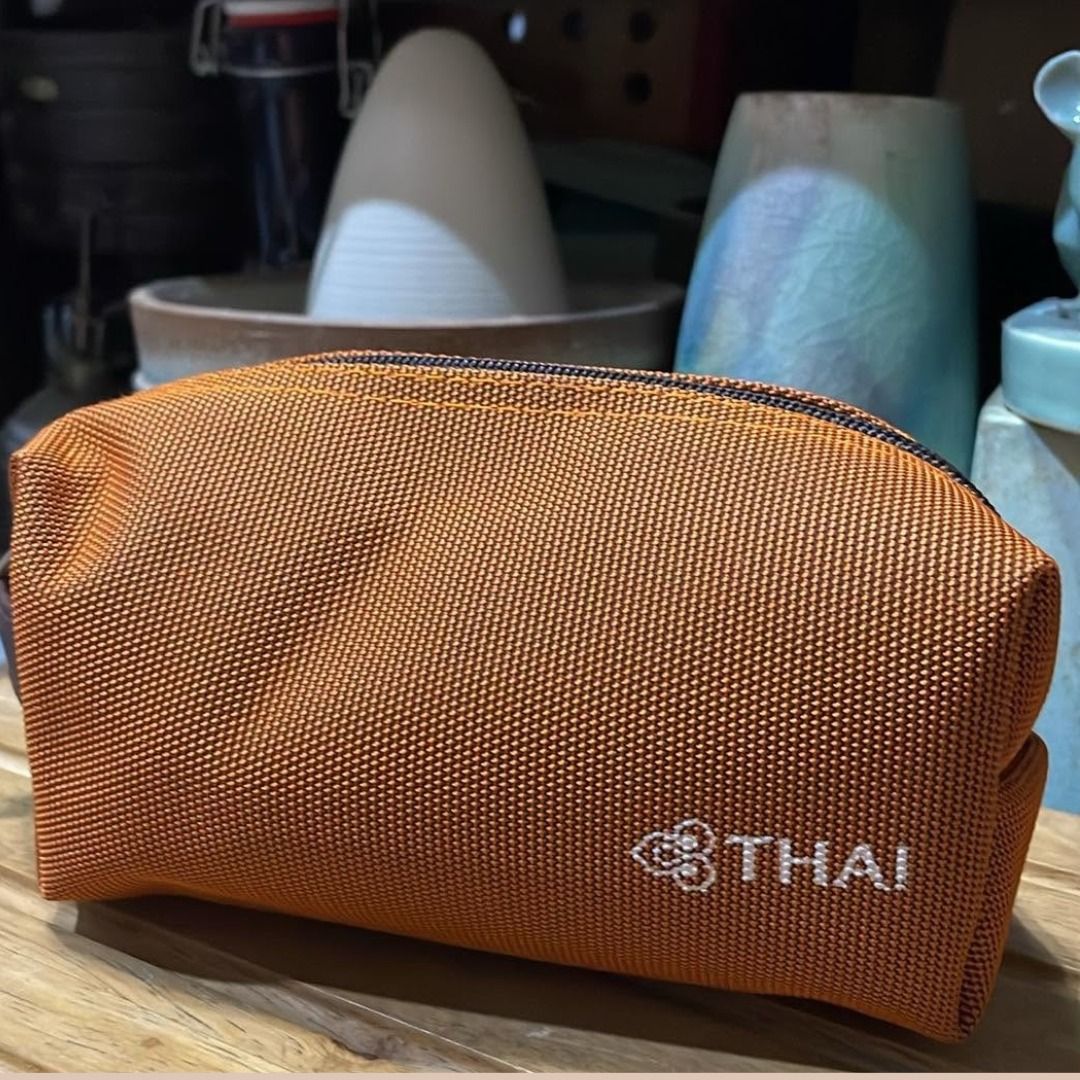 THAI Airways Orange Amenity Kit Pouch (Category: Purses & Pouches) located in Quezon City. Submitted by eilgaraje (Listing ID 1468284043, Image 1). Description: - Authentic Thai Airways amenity pouch - Vibrant orange textured weave fabric with embroidered logo - Dark brown zipper and matching side handle with embossed icon pull - Perfect size for travel toiletries, makeup, or small tech accessories as posted used in good condition.